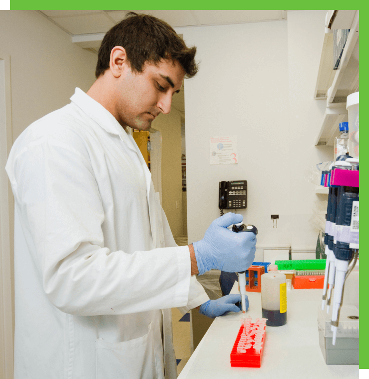 Scientist in lab using a pipette.